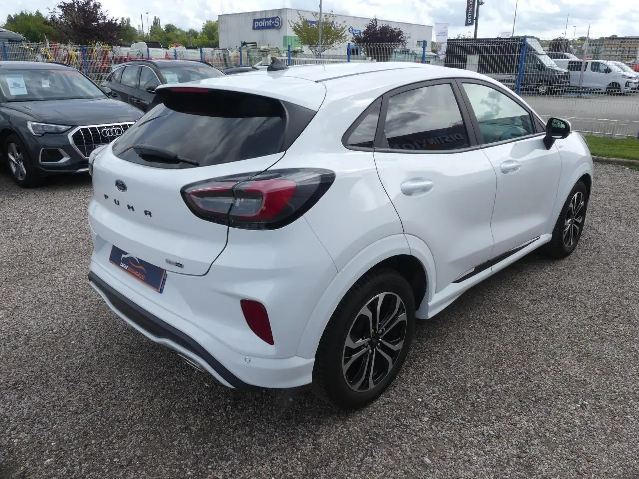 Ford Puma blanc en vue 3/4 arrière droit avec vitres arrière surteintées et jantes alliage noires.