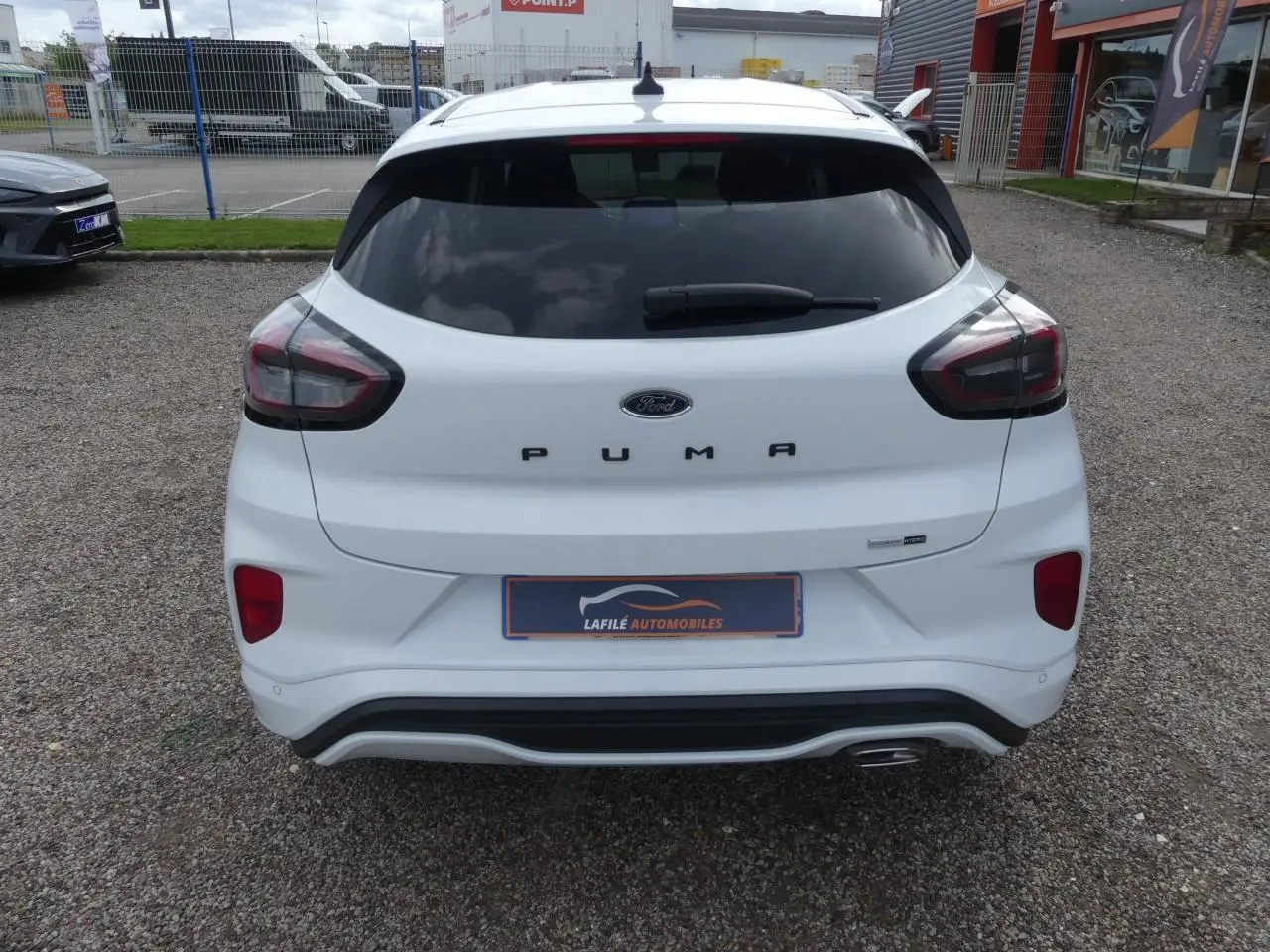 Vue arrière d'une Ford Puma blanche avec vitres arrière surteintées et logo Puma bien visible.