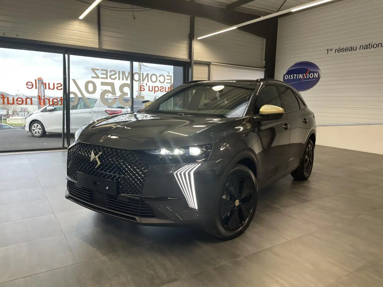 DS7 Crossback gris titanium en 3/4 avant droit, avec calandre noire brillante et coques de rétroviseurs dorées satinées.