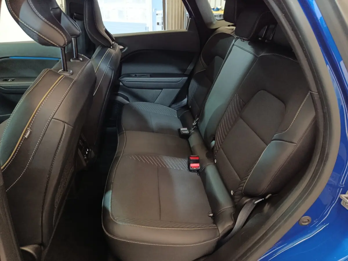 Vue intérieure côté droit des sièges arrière noirs du Renault Symbioz bleu, soulignant la finition et les surpiqûres.