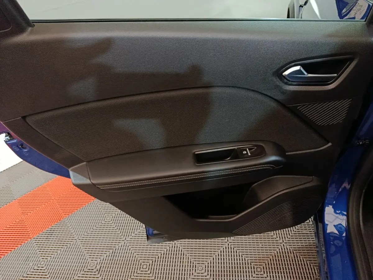 Vue rapprochée de la porte avant gauche bleu Renault Symbioz 2025, avec commande de vitre et garniture noire.