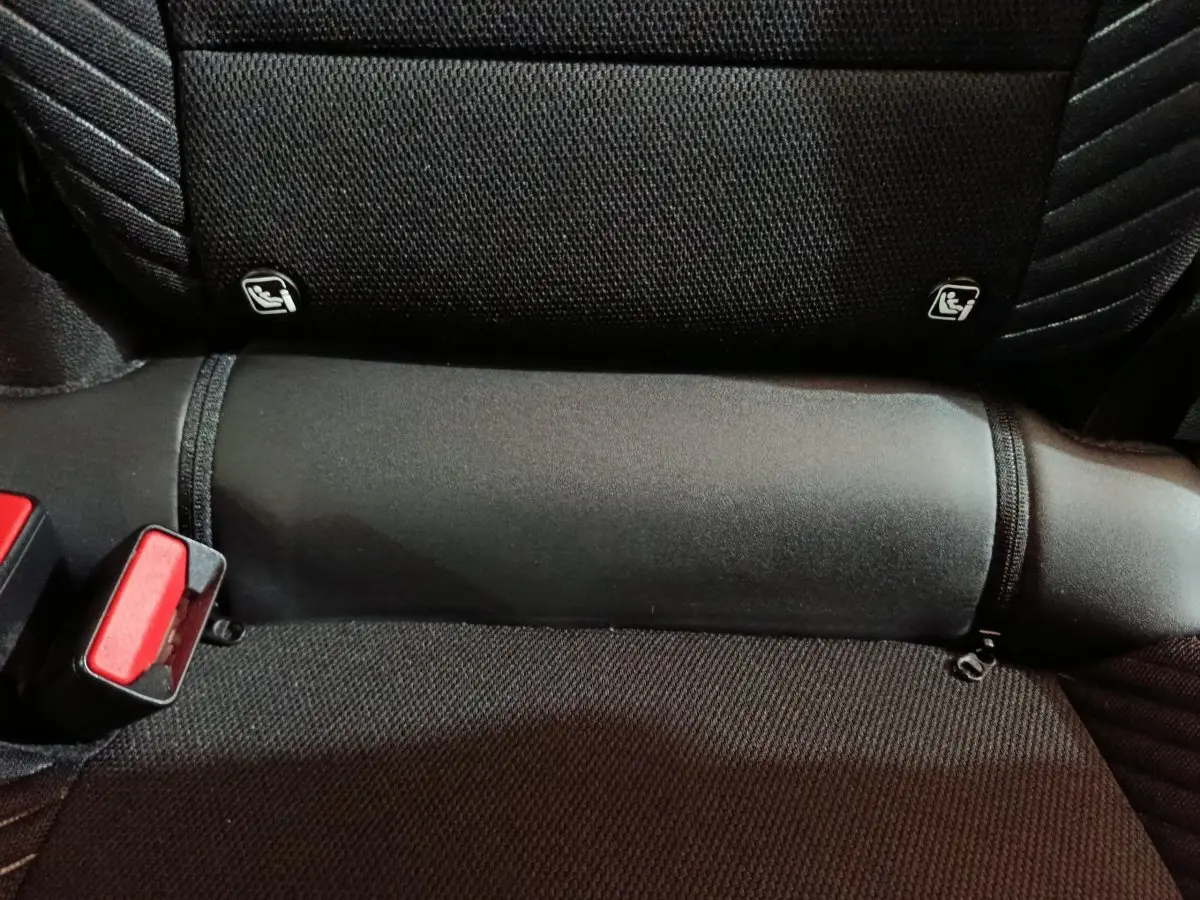 Détail de la banquette arrière noire de la Renault Symbioz 2025 avec fixation Isofix et boucle de ceinture rouge visible.