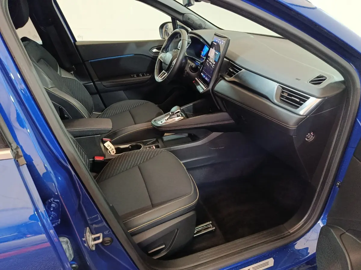 Vue intérieure côté conducteur de la Renault SYMBIOZ bleu 2025, avec tableau de bord moderne et écran tactile vertical.