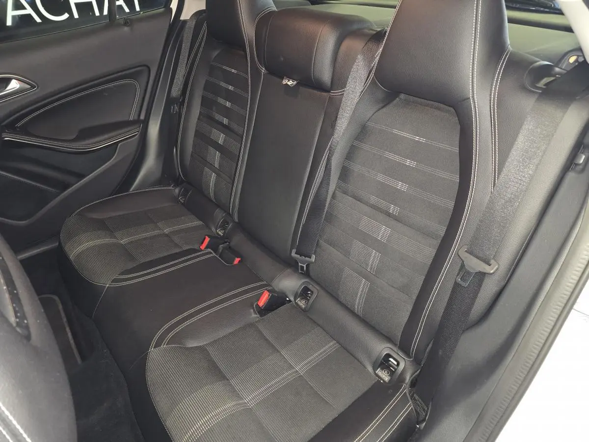 Vue intérieure côté gauche des sièges arrière noirs avec surpiqûres blanches d'une Mercedes GLA 220 d Sensation 4-Matic 2017.