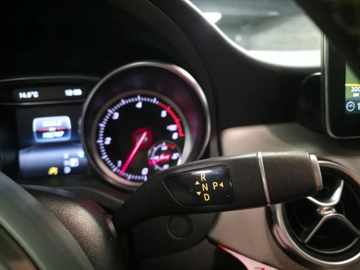 Gros plan sur la commande de boîte automatique avec tableau de bord et aérateur rond du Mercedes GLA blanc 220 d Sensation 2017.