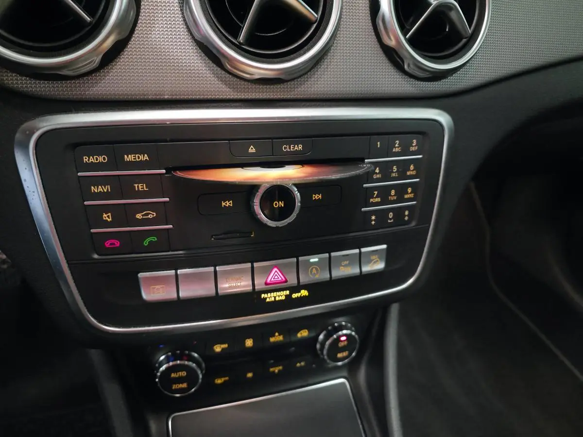 Vue rapprochée du tableau de bord noir et argenté du Mercedes GLA 220 d 2017 avec commandes multimédia et climatisation.