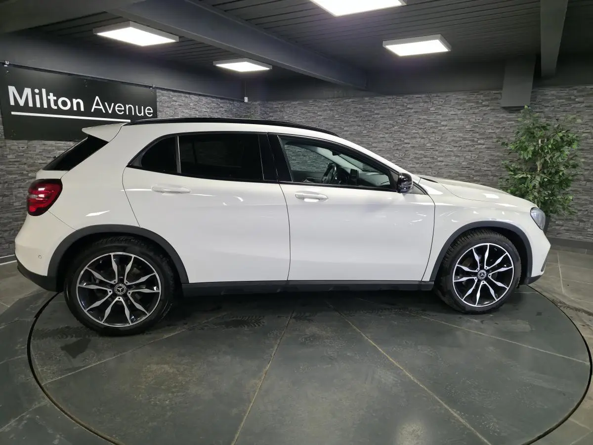Vue profil côté gauche d'un Mercedes GLA blanc avec jantes alliage 19 pouces et vitres arrière surteintées.