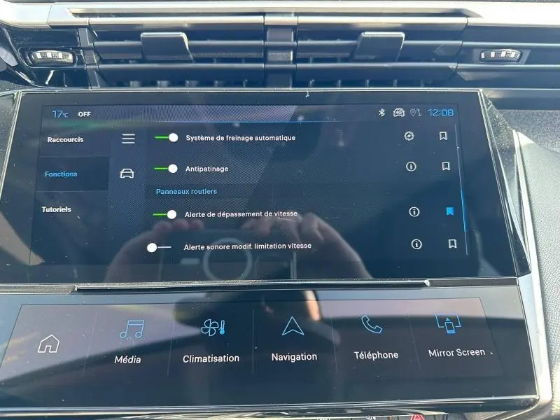 Vue rapprochée de l’écran tactile central de la Peugeot 308 bleu, affichant les réglages d’aides à la conduite.