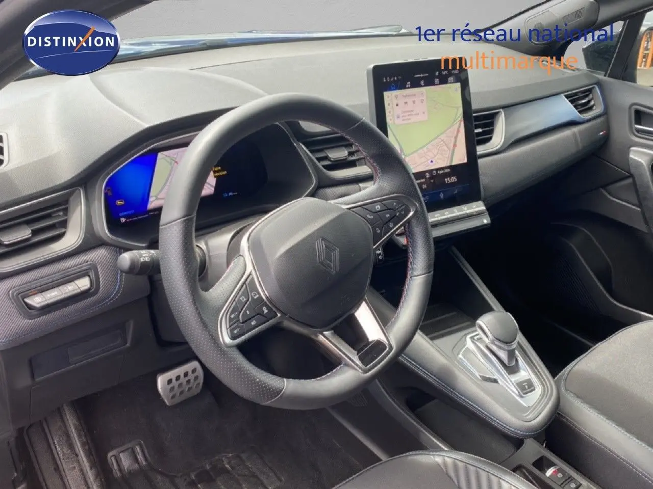 Intérieur de la Renault Symbioz 2025 en vue de côté gauche, volant cuir, écran tactile vertical et console centrale moderne.