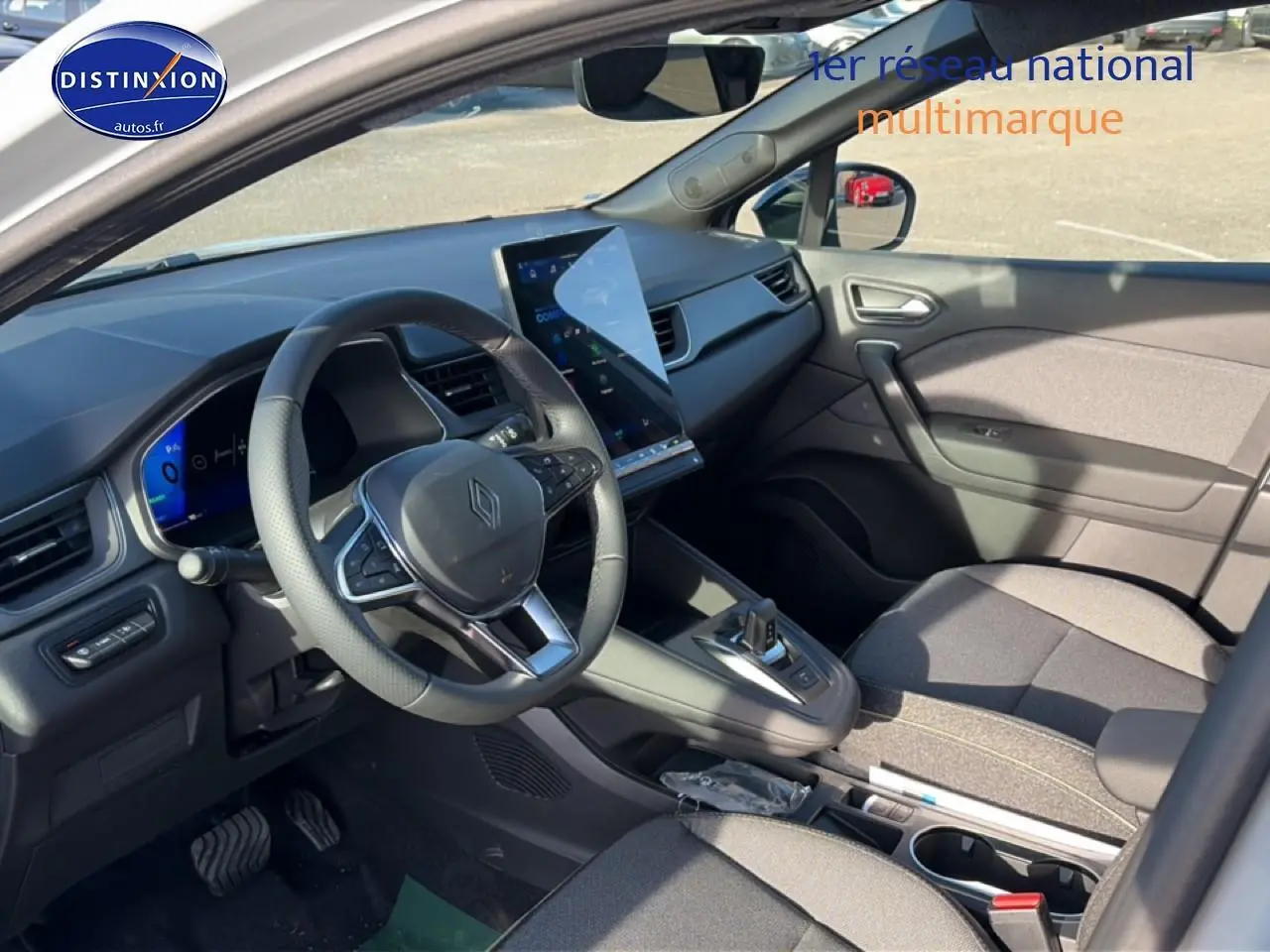 Vue intérieure côté conducteur du Renault Symbioz gris rafale, avec écran tactile vertical et volant multifonction.