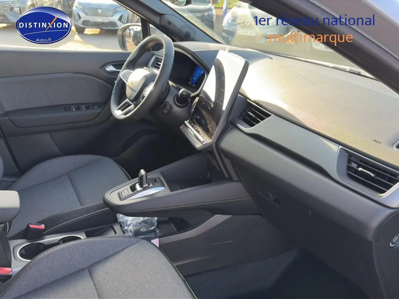Intérieur avant droit de la Renault Symbioz gris rafale, avec tableau de bord moderne et écran tactile vertical.