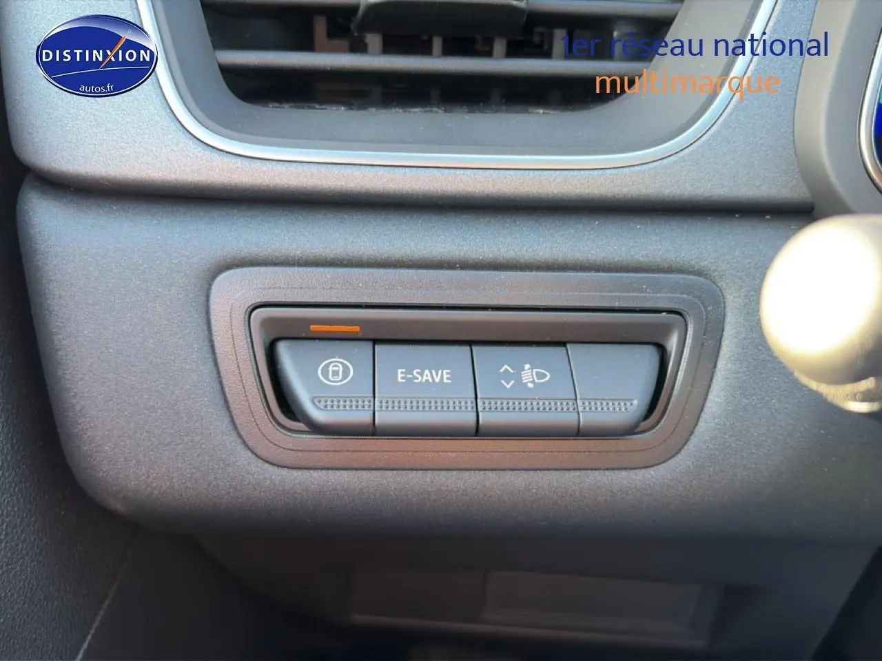 Gros plan sur les boutons de commande E-SAVE et réglage des phares dans l’habitacle gris du Renault Symbioz 2026.