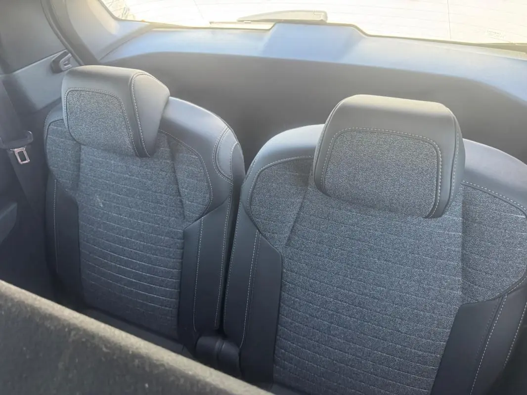 Vue rapprochée des sièges arrière gris en tissu et cuir du Peugeot 5008 Hybrid 2025, version Allure.