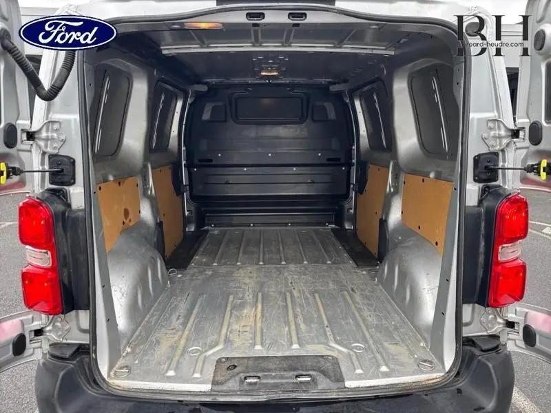 Vue arrière intérieure du fourgon gris aluminium Citroën Jumpy 2018, montrant l'espace de chargement vide et la cloison pleine.