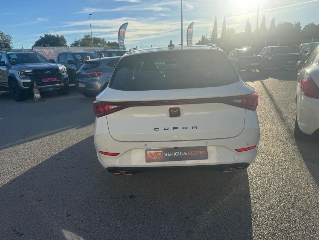 Vue arrière d’un CUPRA Leon Sportstourer blanc 2024 avec feux reliés et double sortie d’échappement intégrée.