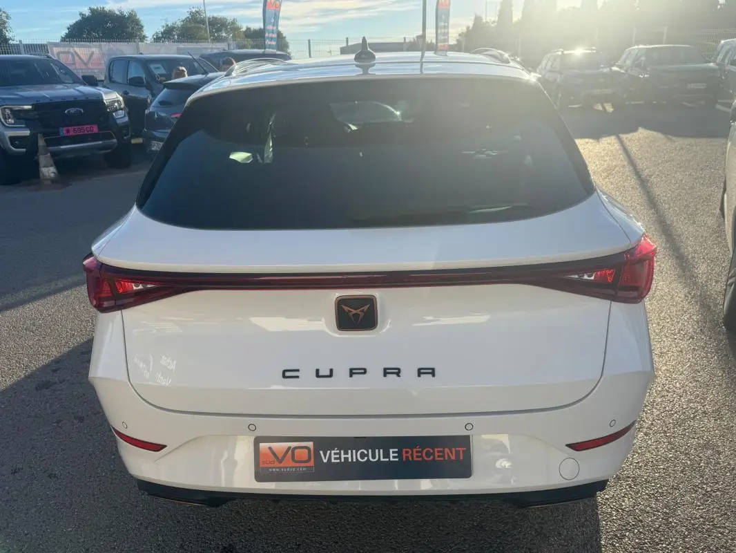Vue arrière d'une CUPRA Leon Sportstourer blanche 2024 avec feu arrière continu et logo CUPRA central.
