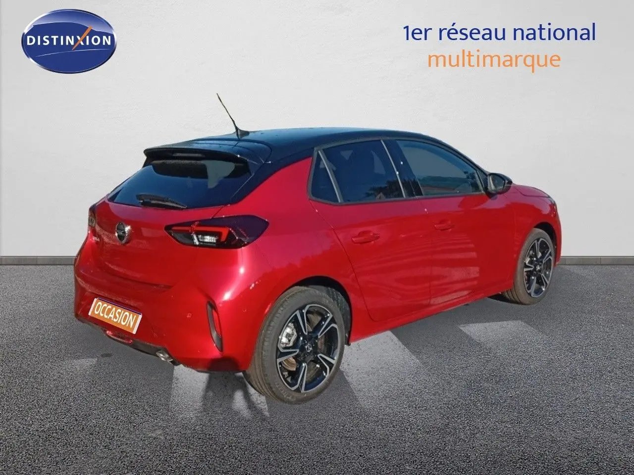 Vue 3/4 arrière droite d'une Opel Corsa rouge Kardio métal avec toit noir et jantes alliage noires.