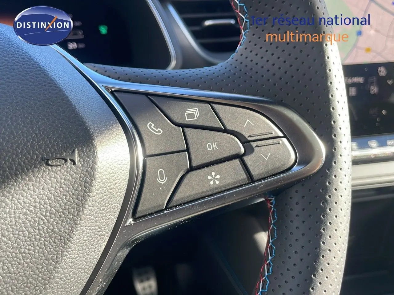 Gros plan sur les commandes multifonctions du volant en cuir perforé noir du Renault Captur E-Tech gris rafale 2025.