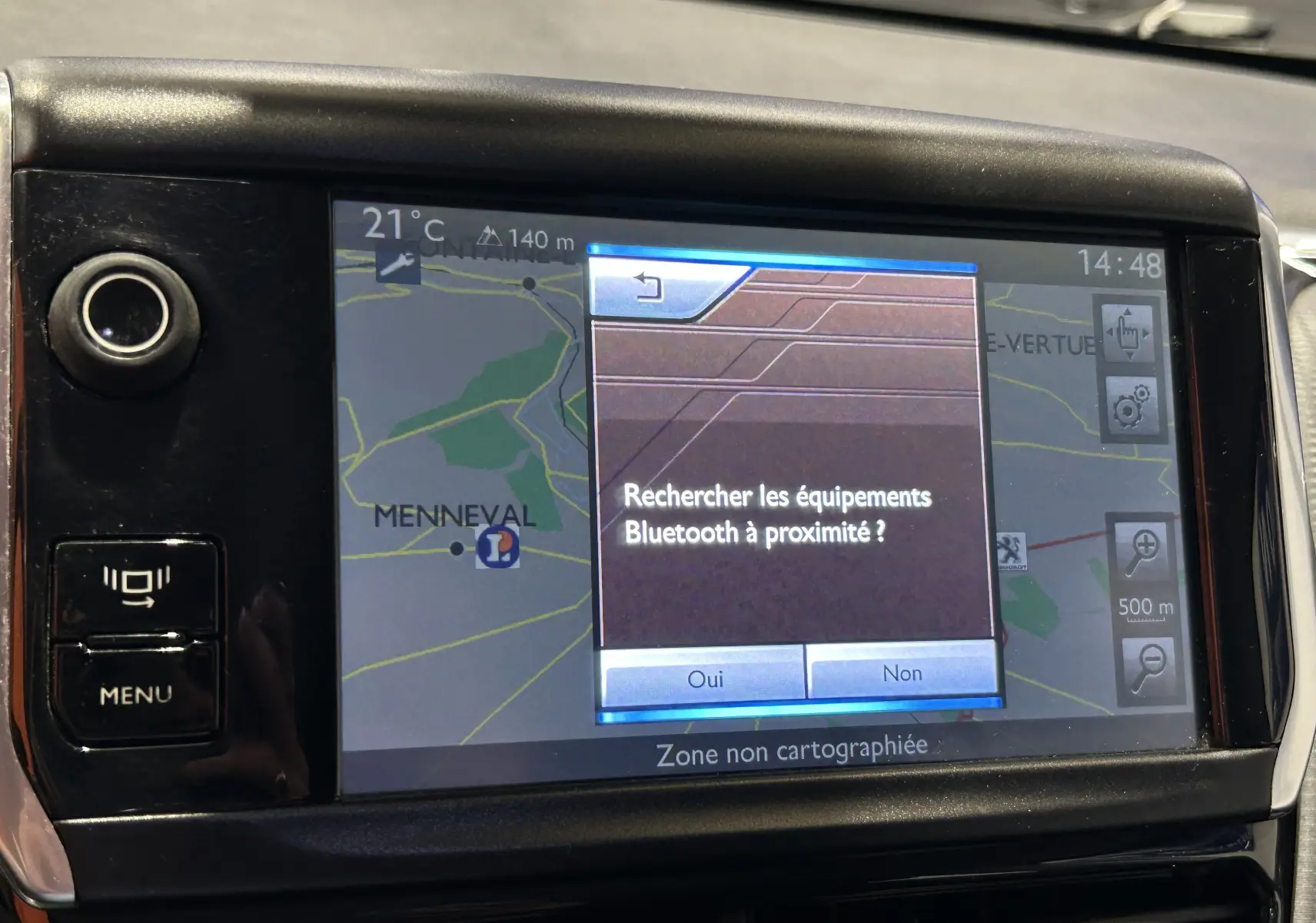 Gros plan sur l’écran GPS tactile du tableau de bord du Peugeot 2008 blanc, affichant une recherche Bluetooth.