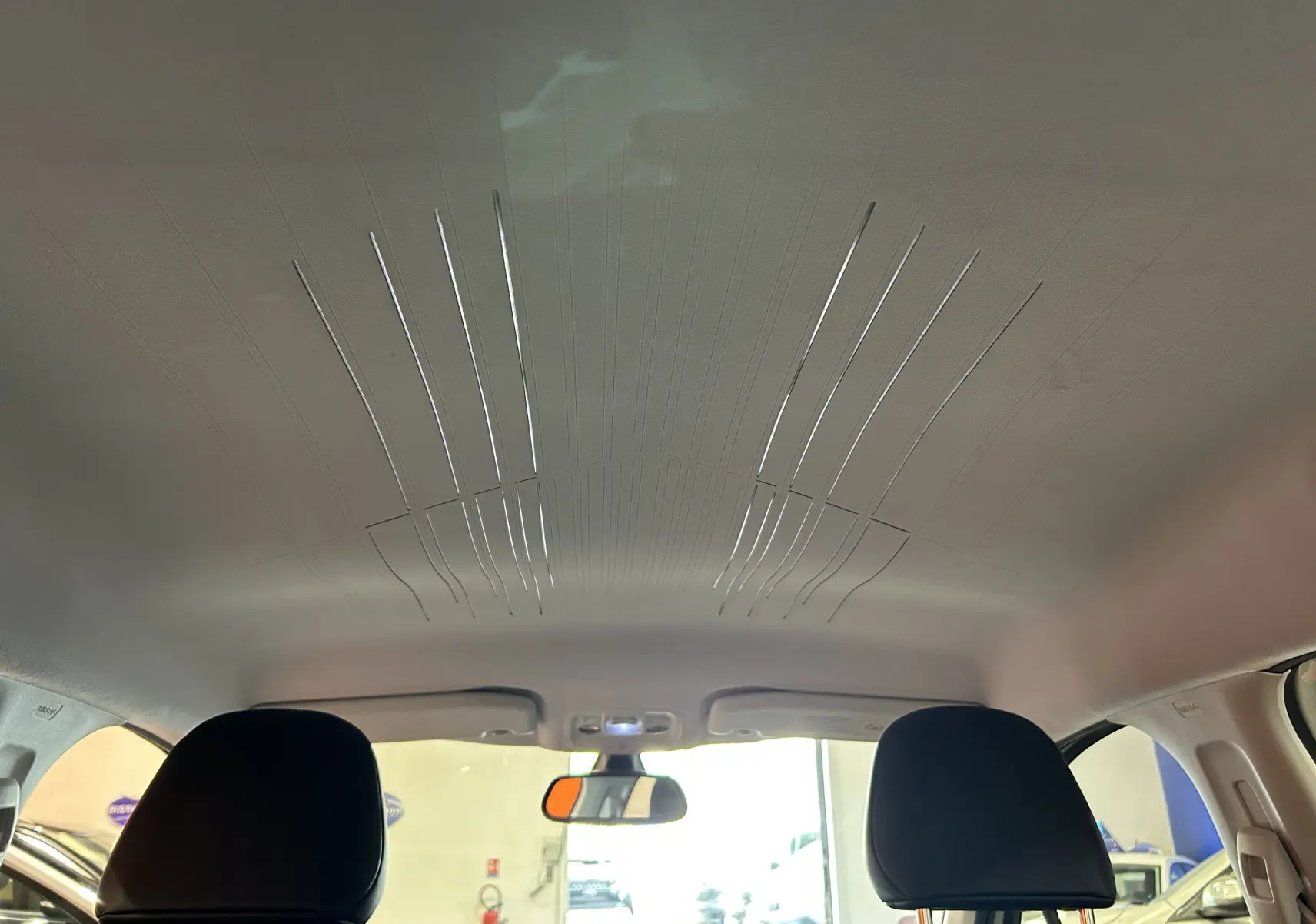 Vue intérieure du plafond et des appuie-têtes avant d'une Peugeot 2008 blanche, version VTi 82 Allure.