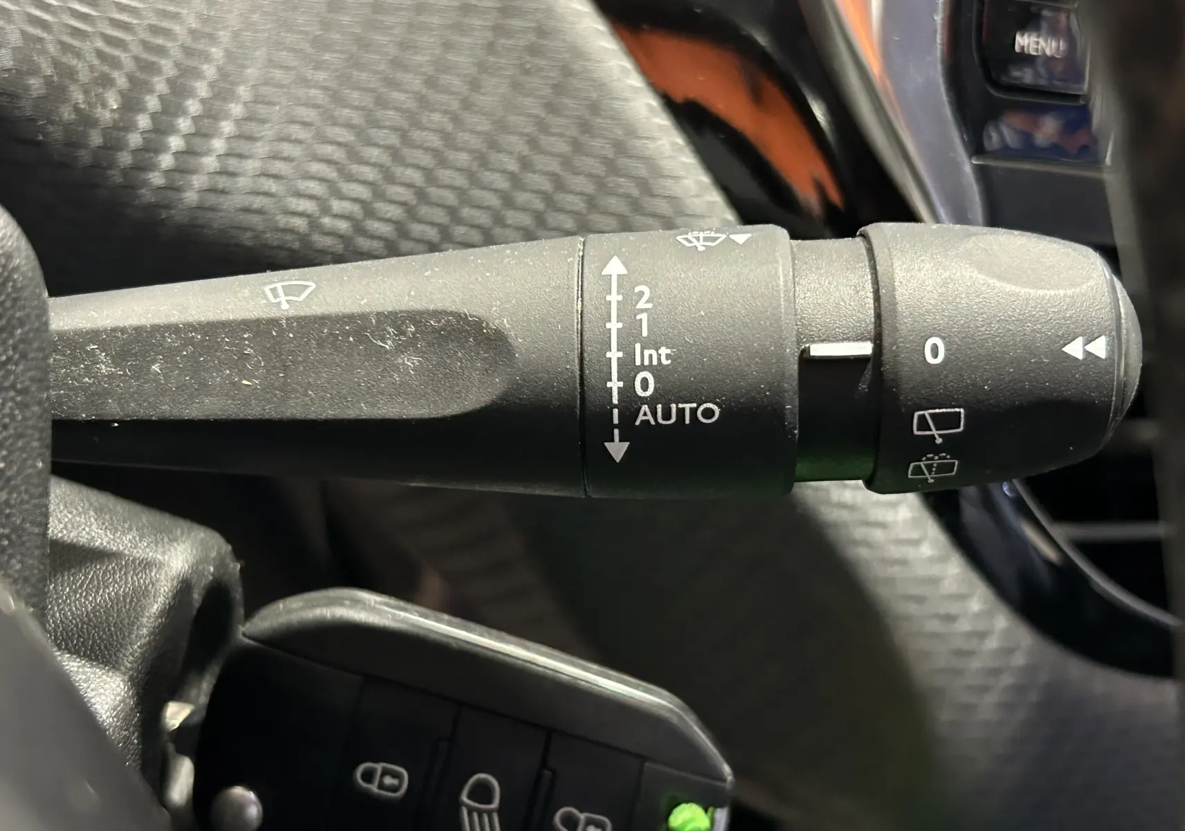 Gros plan sur la commande d’essuie-glace noire dans l’habitacle d’une Peugeot 2008 blanche de 2014.