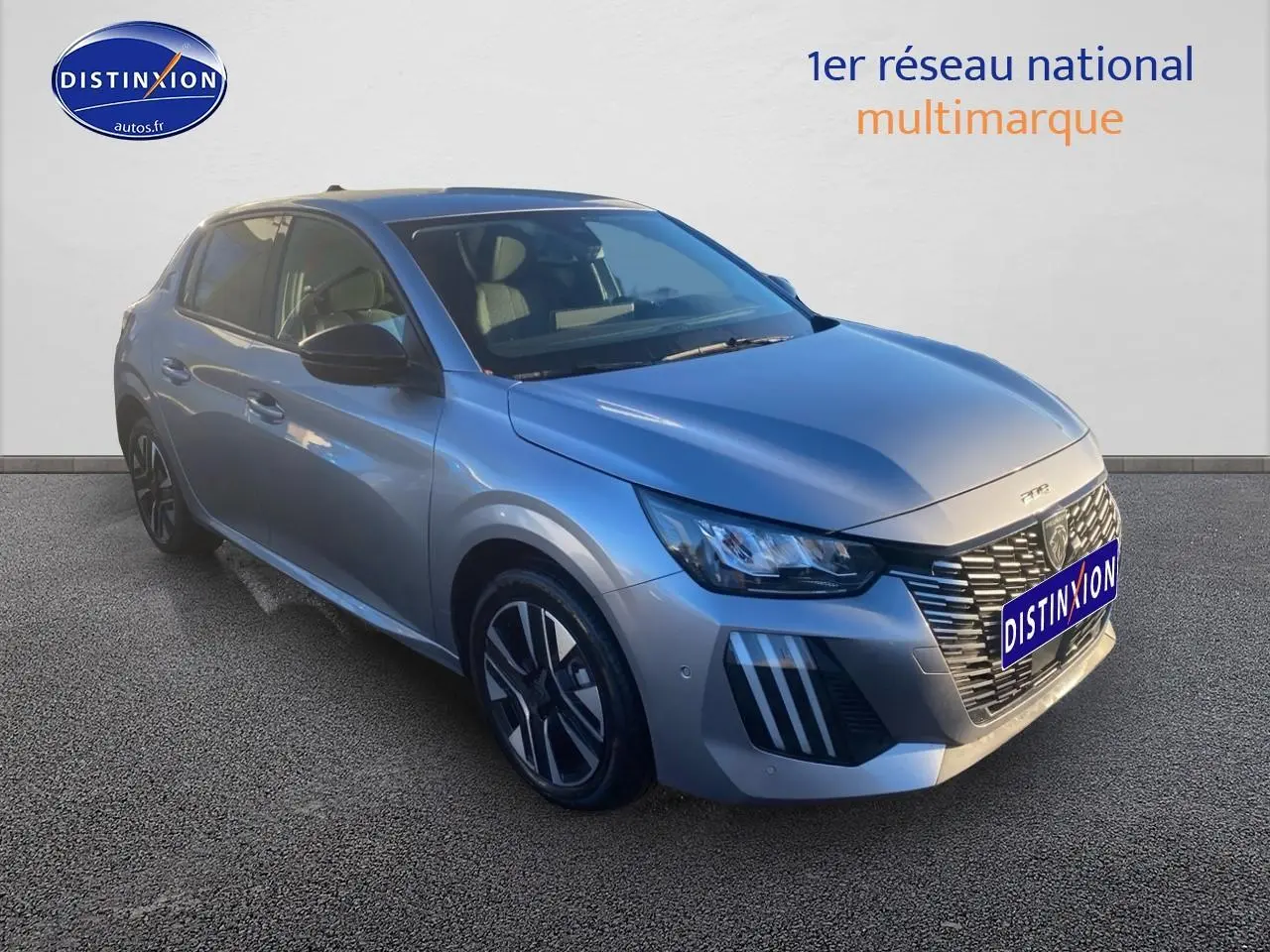 Peugeot 208 gris artense vue 3/4 avant droit avec calandre distinctive et jantes alu modernes.