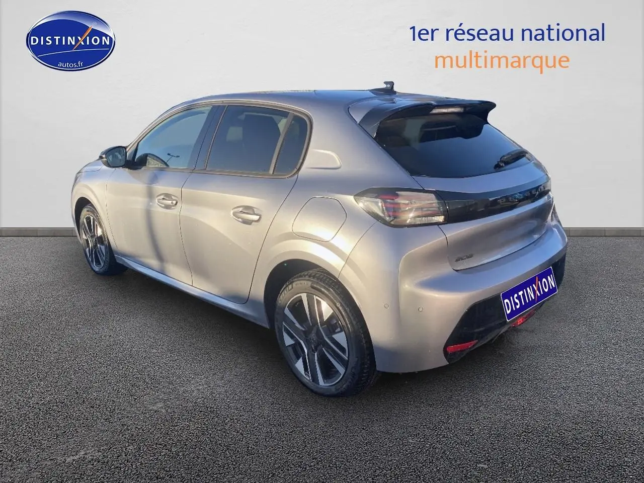 Peugeot 208 gris artense vue 3/4 arrière droit, avec jantes alu et vitres arrière teintées.