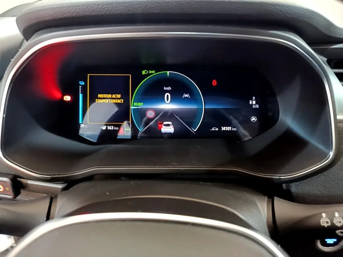 Vue rapprochée du combiné d'instruments numérique de la Renault ZOE Business R110 blanc, affichant 0 km/h et alertes moteur.