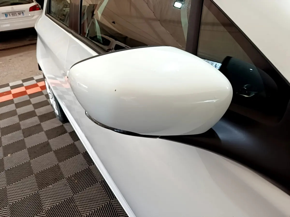 Gros plan sur le rétroviseur côté gauche blanc d'une Renault ZOE Business R110 blanche, vue partielle de la portière.