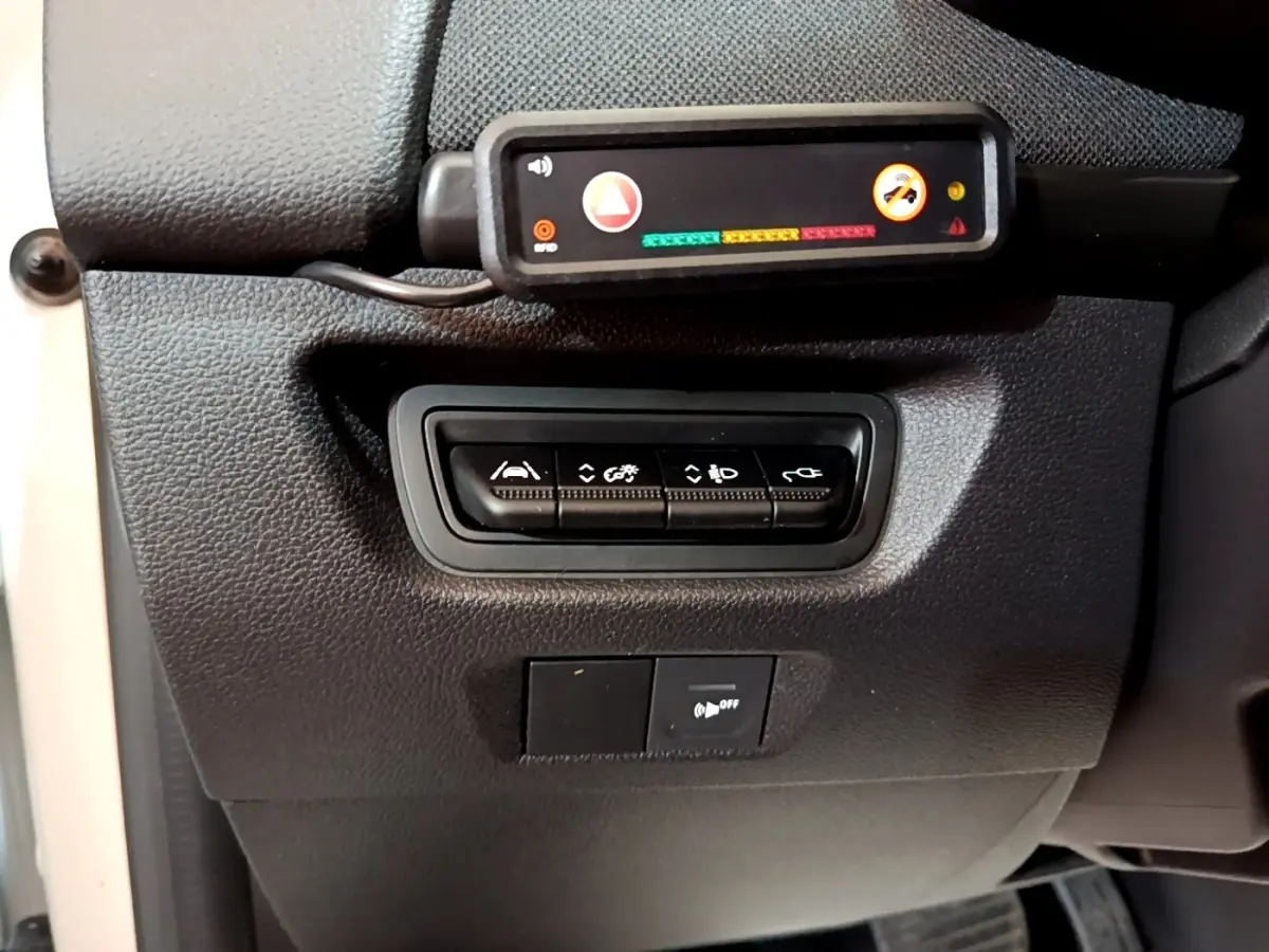 Gros plan sur les commandes de réglages et capteurs situés à gauche du volant dans une Renault ZOE Business R110 blanche de 2021.