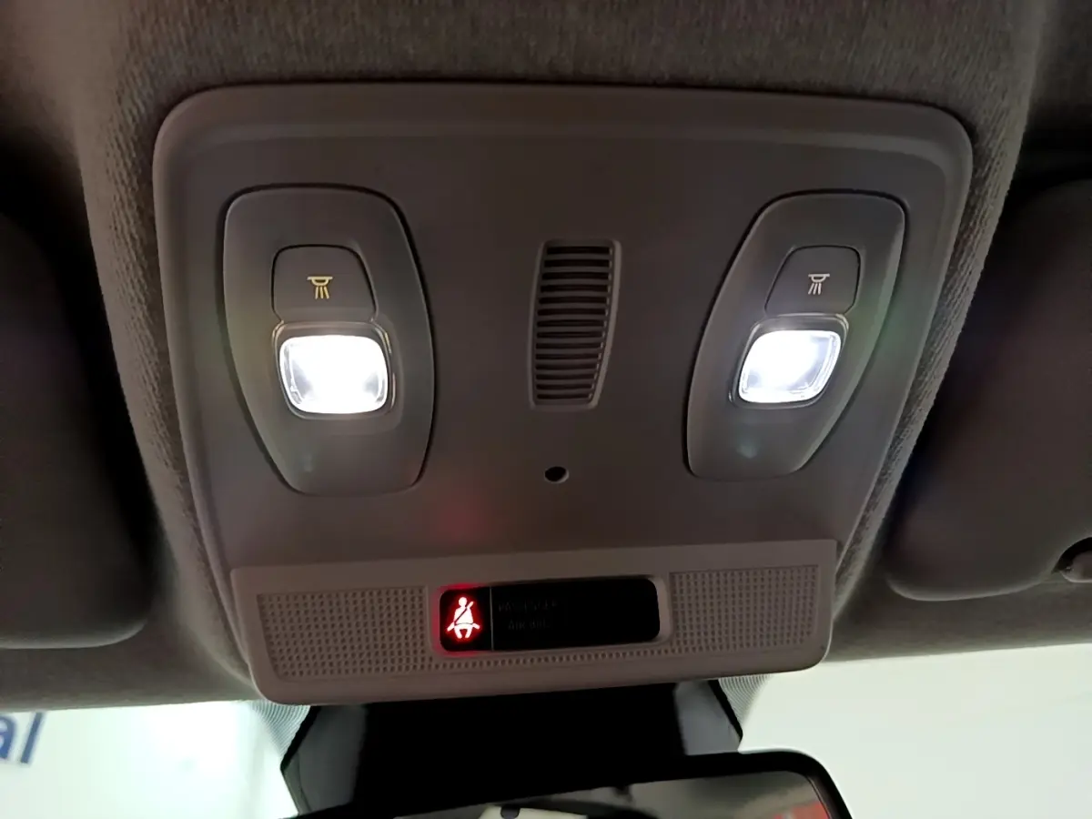 Plafonnier intérieur avec éclairage LED allumé et témoin de ceinture de sécurité rouge dans une Renault ZOE blanche de 2021.