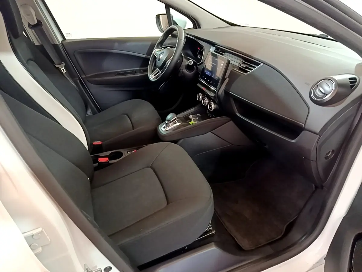Intérieur avant droit de la Renault ZOE Business R110 blanc, avec tableau de bord moderne et écran tactile central.