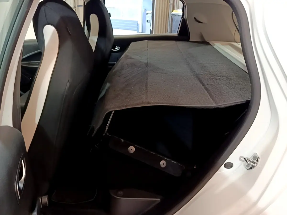 Vue intérieure côté droit de la Renault ZOE Business R110 blanche, banquette arrière rabattue et couverture grise.