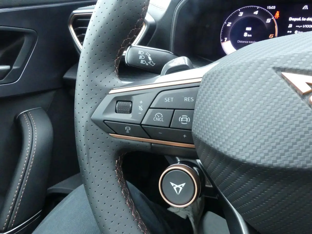 Gros plan sur le volant perforé gris avec surpiqûres cuivrées et commandes multifonctions du CUPRA Formentor 2025.