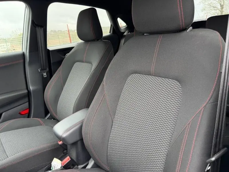 Vue intérieure rapprochée des sièges avant sport noirs avec surpiqûres rouges du Ford Puma 2024 ST-Line.