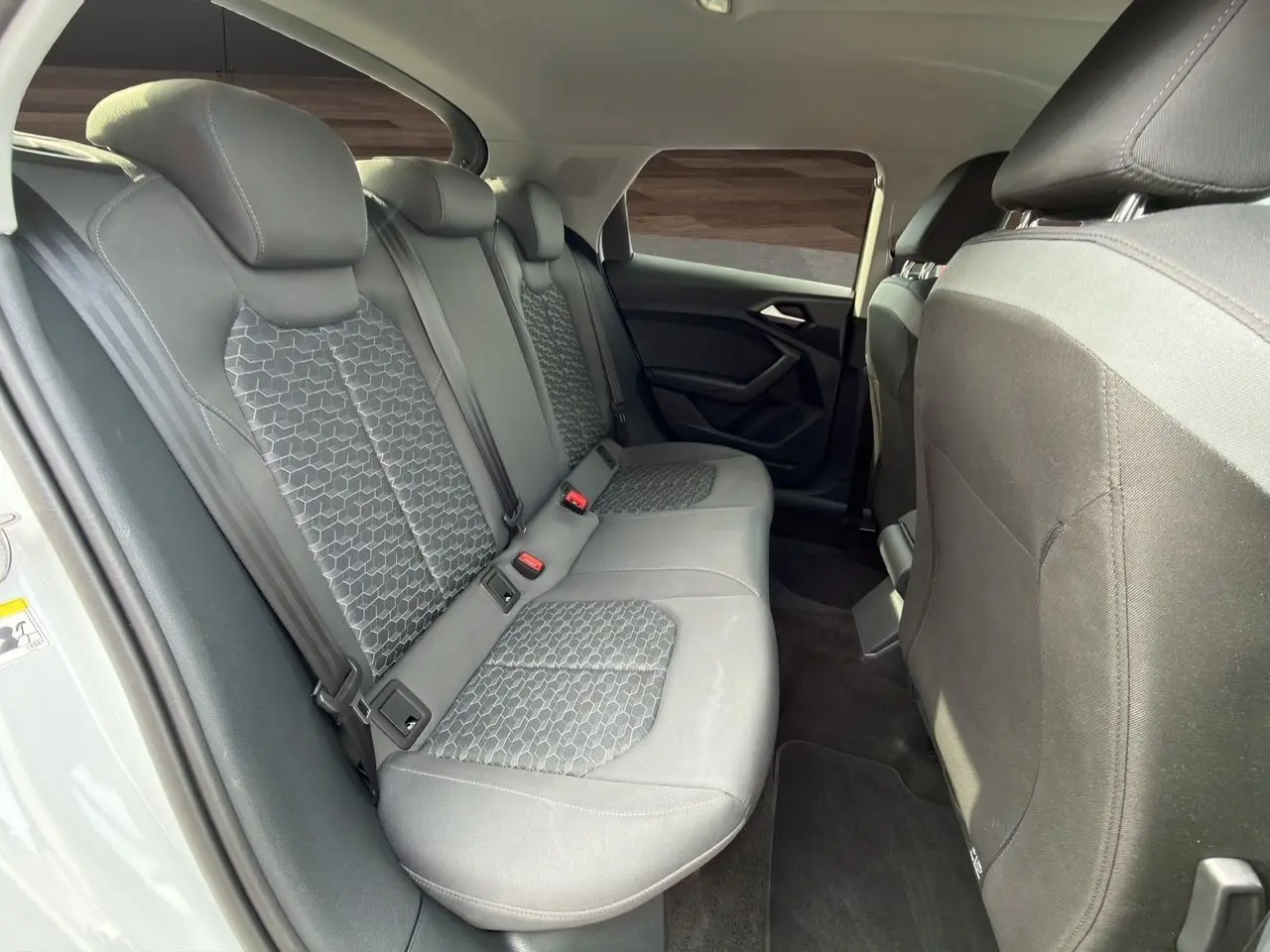 Vue intérieure des sièges arrière en tissu noir avec motifs hexagonaux de l'Audi A1 Sportback 2025.