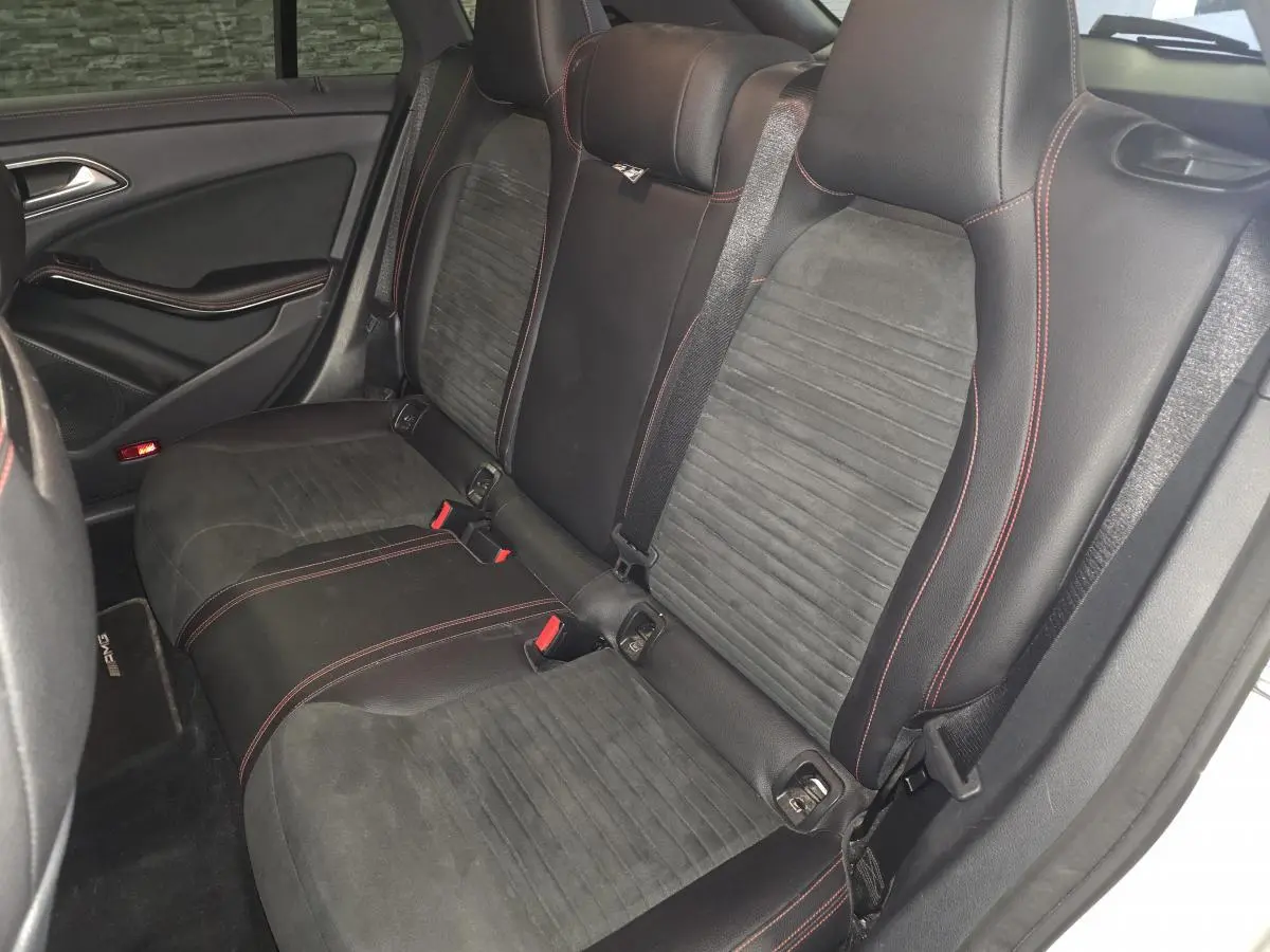 Vue intérieure côté droit des sièges arrière noirs en cuir et microfibre avec surpiqûres rouges d'une Mercedes CLA Shooting Brake AMG 2016.