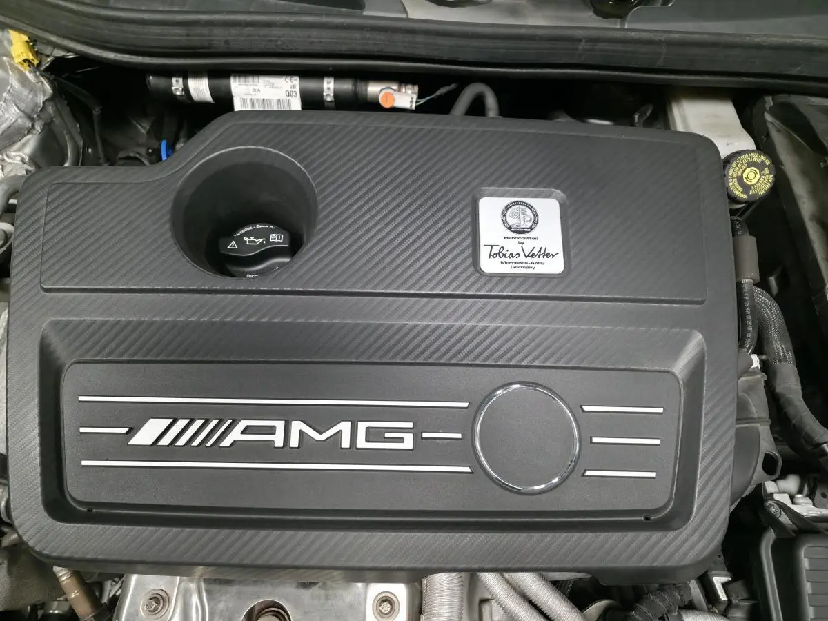 Vue rapprochée du moteur AMG noir avec plaque nominative Tobias Vetter sur Mercedes CLA Shooting Brake gris.