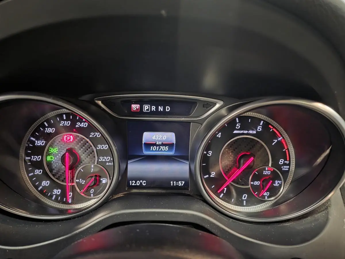 Vue rapprochée du combiné d'instruments AMG avec compte-tours, compteur de vitesse et écran digital affichant la température et le kilométrage.