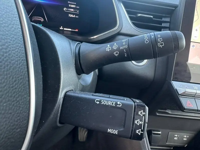 Gros plan sur les commandes au volant du Renault Captur 2025, avec tableau de bord numérique et finition intérieure noire.