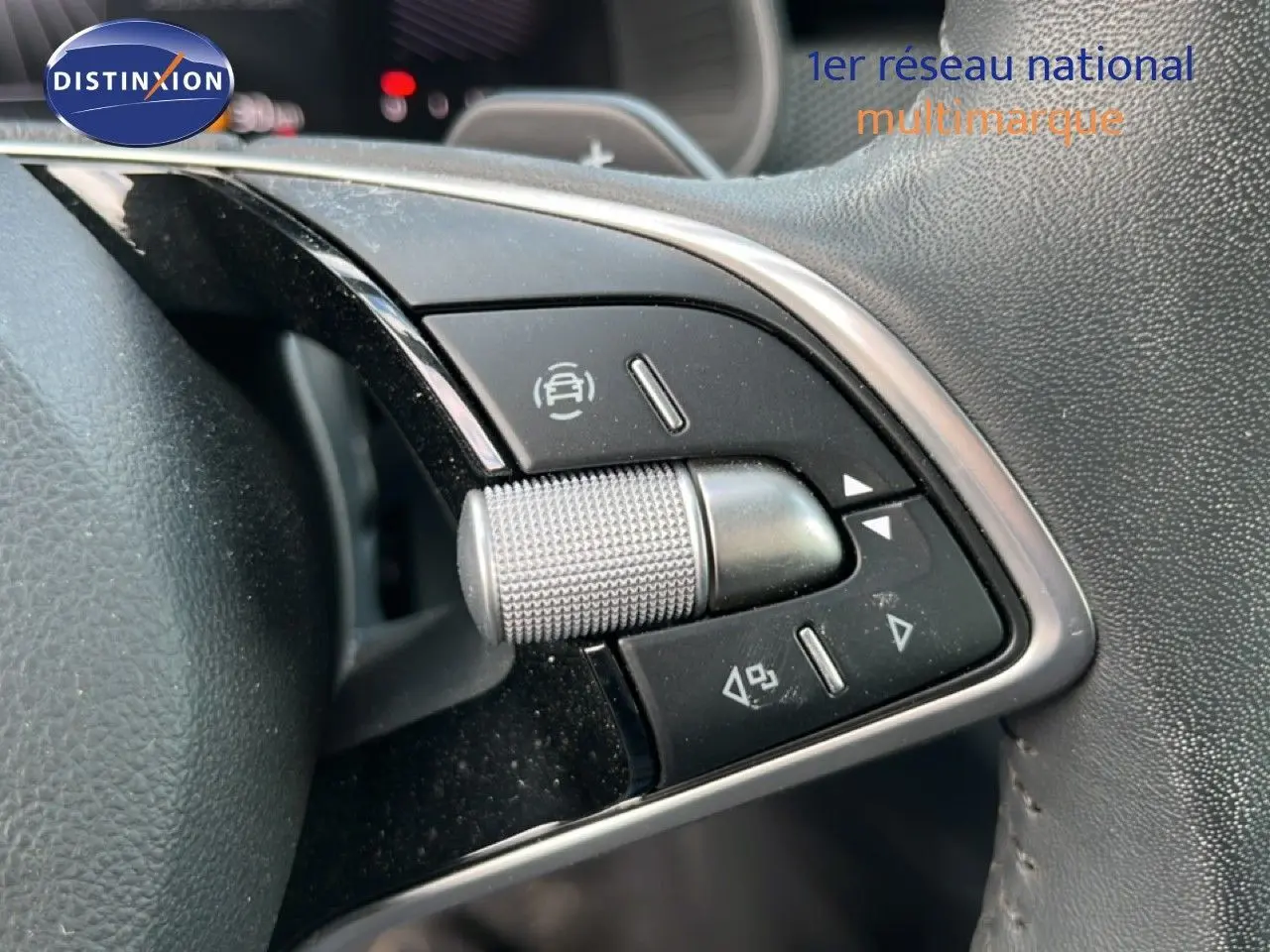 Gros plan sur les commandes multifonctions argentées et noires du volant côté gauche d'une Skoda Scala gris magnétique.