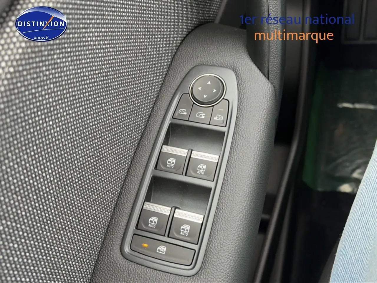 Gros plan sur les commandes des vitres électriques et rétroviseurs sur la porte côté conducteur du Renault Symbioz bleu mercure.