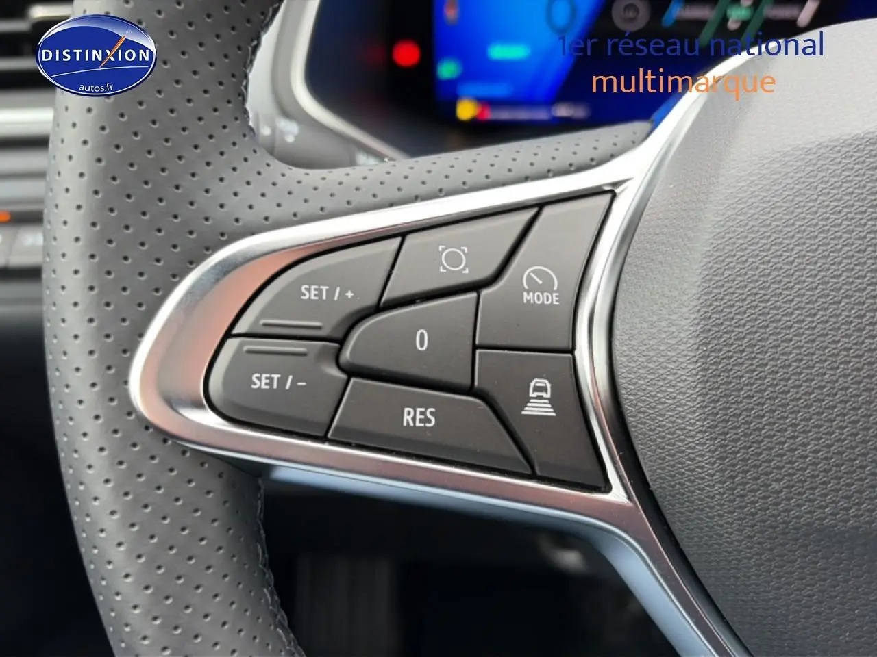 Gros plan sur les commandes du volant à gauche de la Renault Symbioz 2026, cuir perforé et boutons multifonctions noirs.