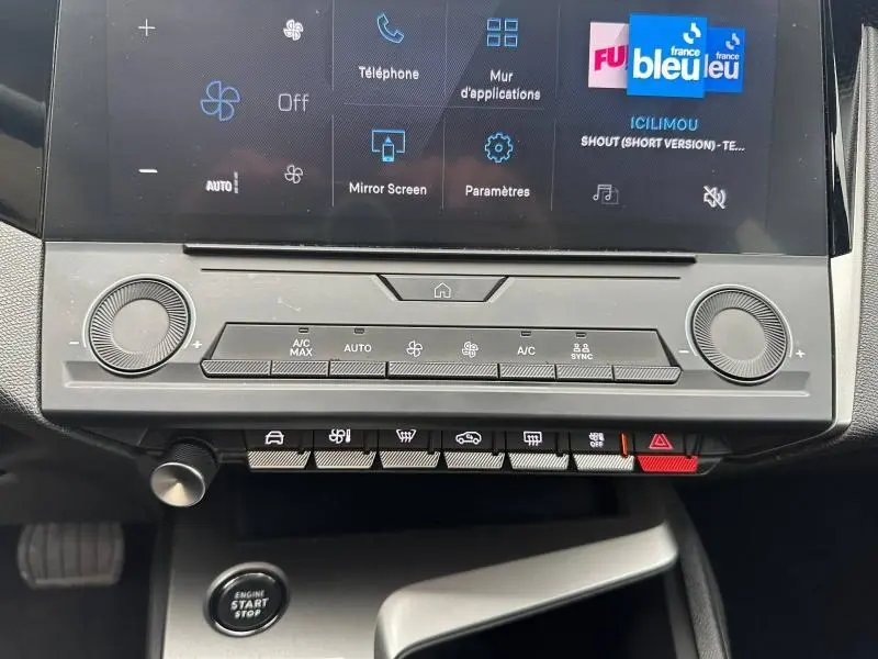 Vue rapprochée de la console centrale de la Peugeot 308 2024 avec commandes climatisation et écran tactile.