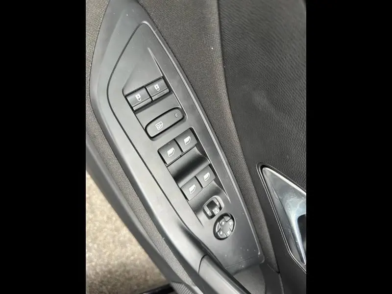 Vue rapprochée des commandes de lève-vitres et rétroviseurs côté gauche d’une Peugeot 308 noire Perla Nera 2024.