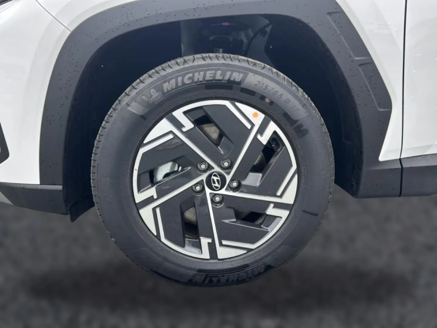Gros plan sur la roue avant gauche blanche d’un Hyundai Tucson 2026 avec jante alliage noire et argentée Michelin.