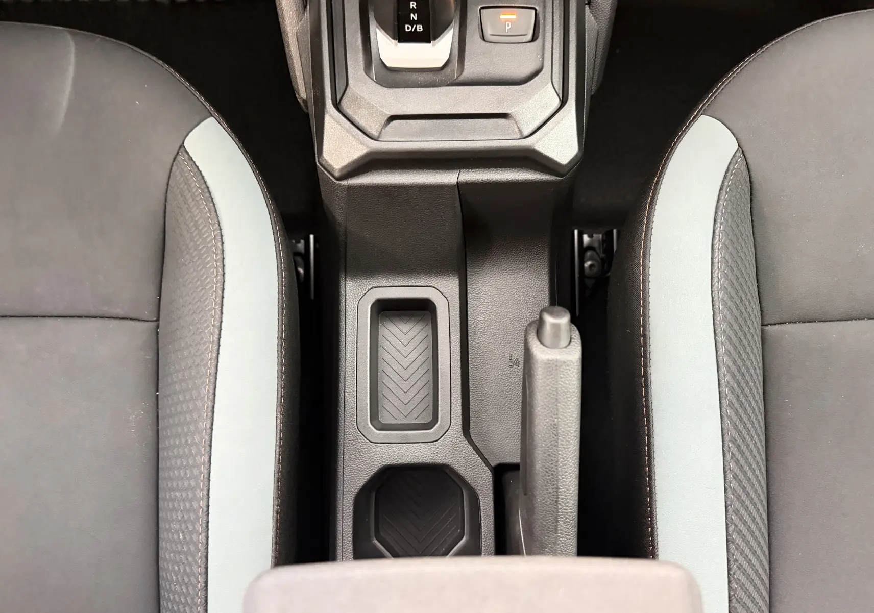 Vue plongeante sur la console centrale et les sièges gris clair et noir du Dacia Duster Hybrid 155 Extreme 2026.