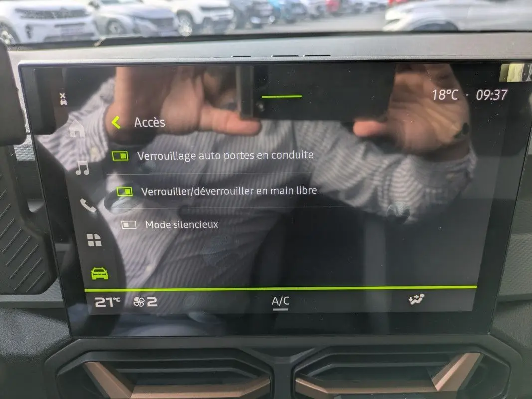 Écran tactile 10,1'' du Dacia Duster Hybrid 155 Extreme affichant les options de verrouillage, avec reflet d’une personne.