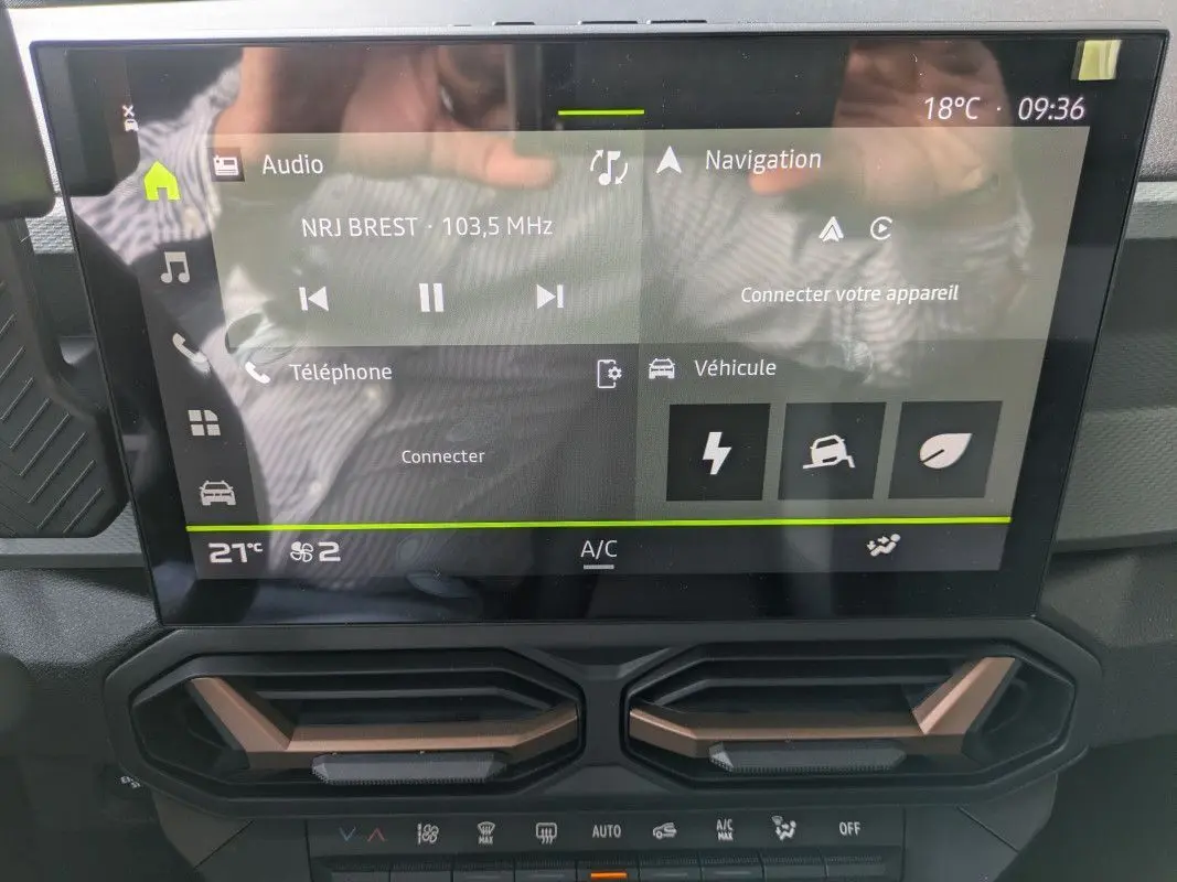 Écran tactile 10,1'' du tableau de bord du Dacia Duster Hybrid 155 Extreme avec commandes climatisation et détails brun cuivré.