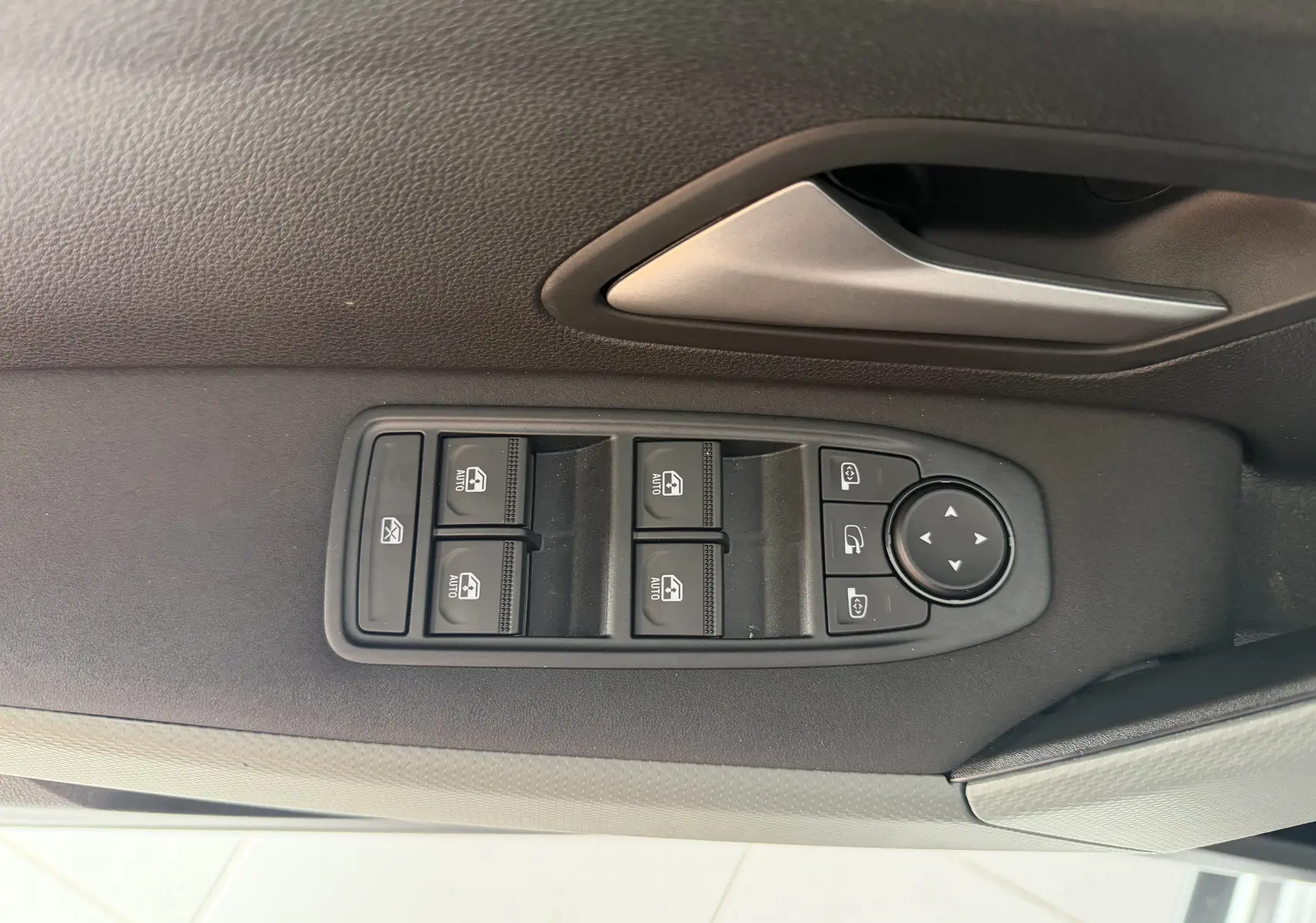 Gros plan sur les commandes des vitres et rétroviseurs côté conducteur du Dacia Duster Hybrid 155 Extreme gris schiste.